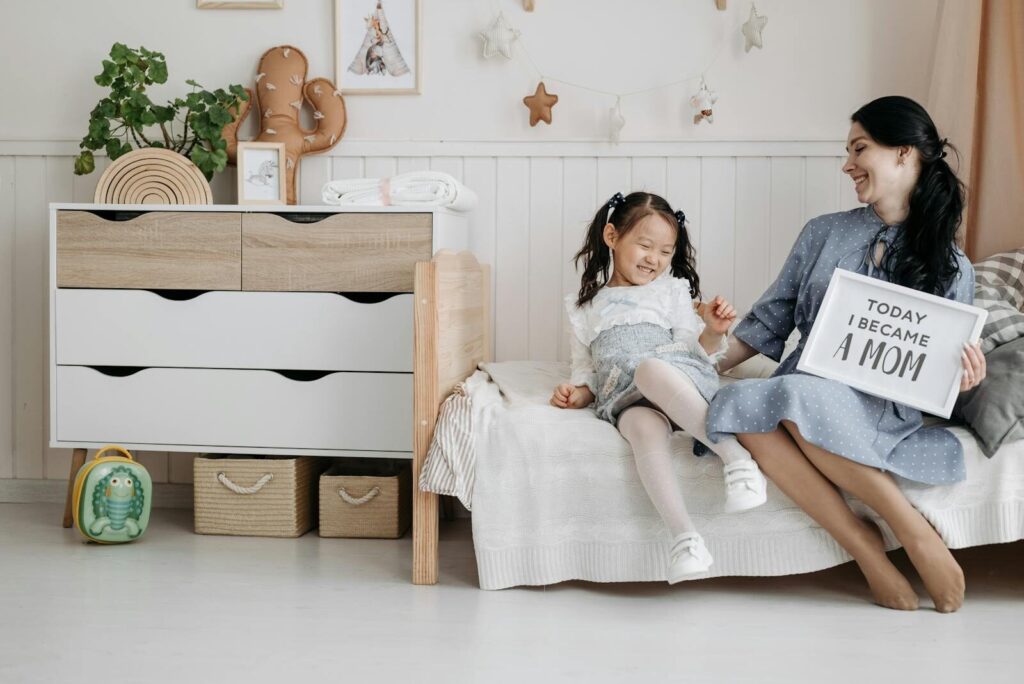 Happy mother and daughter sharing a joyful moment in a cozy bedroom setting.